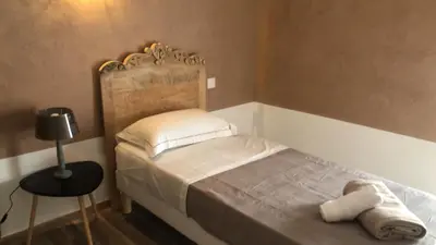 a small bedroom with a bed and a table at La pause du canal in Trèbes