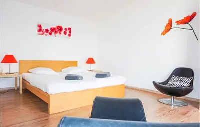 a bedroom with a bed and a black chair at Lovely Home In Siran With Wifi in Siran