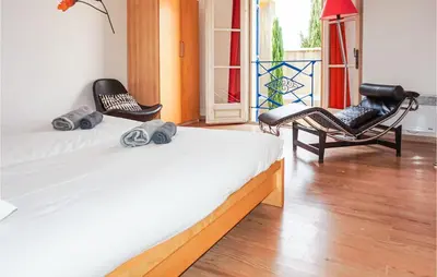 a bedroom with a bed and two chairs and a window at Lovely Home In Siran With Wifi in Siran