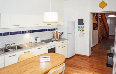 a kitchen with white cabinets and a wooden table at Lovely Home In Siran With Wifi in Siran