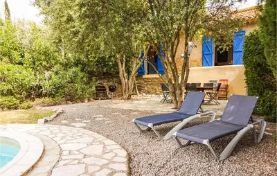 two blue chairs sitting next to a swimming pool at Lovely Home In Siran With Wifi in Siran