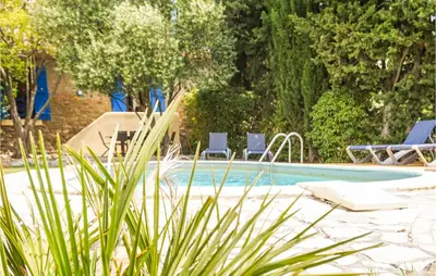 a swimming pool with two lounge chairs next to it at Lovely Home In Siran With Wifi in Siran