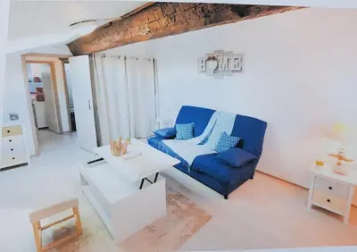 a living room with a blue chair and a table at STUDIO 9 Classé 2 Etoiles in Carcassonne