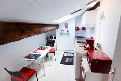 a small kitchen with a table and a red appliance at STUDIO 9 Classé 2 Etoiles in Carcassonne