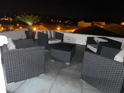 a group of wicker chairs on a balcony at night at Blue Diamond Room in Salles-dʼAude