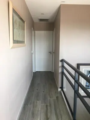 a hallway with a door and a staircase with wood floors at Blue Diamond Room in Salles-dʼAude