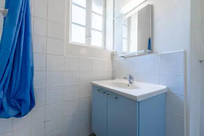 a white bathroom with a sink and a mirror at La Rustique, maison de charme proche Carcassonne - jardin, wifi, tout équipée in Cuxac-Cabardès