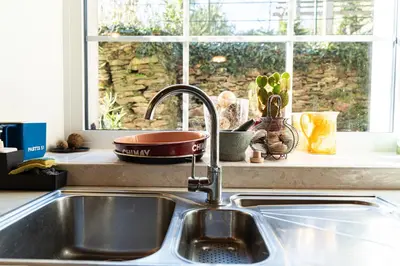 a sink in a kitchen with a window at La Rustique, maison de charme proche Carcassonne - jardin, wifi, tout équipée in Cuxac-Cabardès