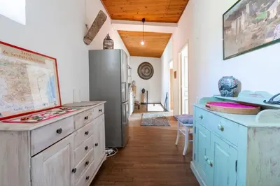 a kitchen with blue cabinets and a refrigerator at La Rustique, maison de charme proche Carcassonne - jardin, wifi, tout équipée in Cuxac-Cabardès