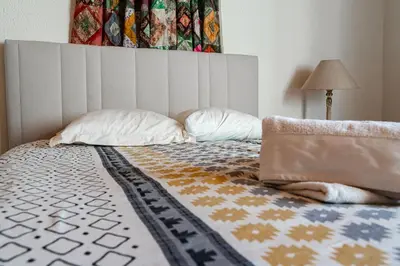 a bed with a headboard and pillows on it at La Rustique, maison de charme proche Carcassonne - jardin, wifi, tout équipée in Cuxac-Cabardès