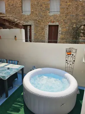 a large hot tub on a patio with a table at Serge Le Belge - Sejour authentique chez l habitant a Lezignan Corbieres in Lézignan-Corbières