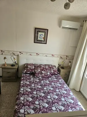a bedroom with a bed with a floral bedspread at Serge Le Belge - Sejour authentique chez l habitant a Lezignan Corbieres in Lézignan-Corbières