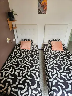 two beds sitting next to each other in a room at Serge Le Belge - Sejour authentique chez l habitant a Lezignan Corbieres in Lézignan-Corbières
