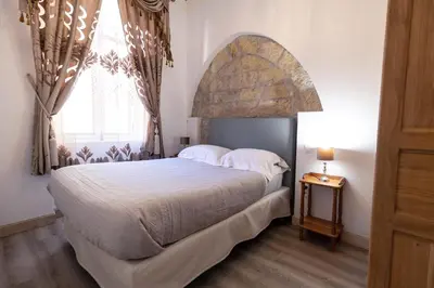a bedroom with a large bed and a large window at Studio familial Maison de L'église du Couvent in Narbonne