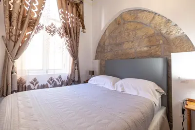 a bedroom with a large bed and a large window at Studio familial Maison de L'église du Couvent in Narbonne