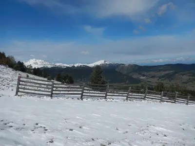 a fence in the snow with mountains in the background at La Caminada Vielha in Montaillou