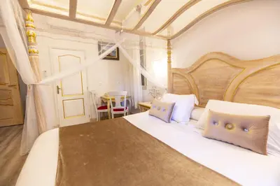 a bedroom with a large white bed with blue pillows at Chambre a Baldaquin Maison de L'Église Du couvent in Narbonne