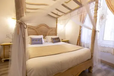 a bedroom with a canopy bed and a window at Chambre a Baldaquin Maison de L'Église Du couvent in Narbonne
