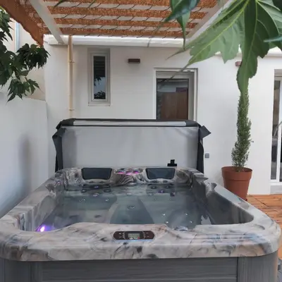 a hot tub in the middle of a yard at LE CELESTHYM - SPA Privatif in Conques-sur-Orbiel