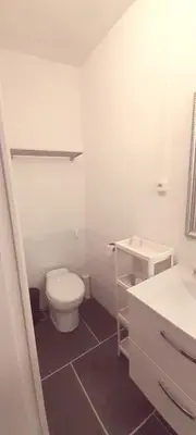 a white bathroom with a toilet and a sink at Sur la Bonnefooi in Prades-sur-Vernazobre