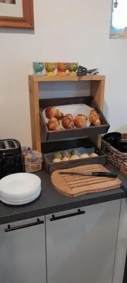 a counter with a shelf with loaves of bread and pastries at Sur la Bonnefooi in Prades-sur-Vernazobre