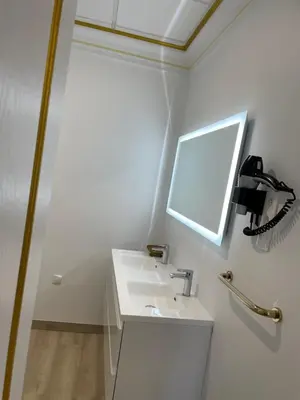a white bathroom with a sink and a mirror at Studio du Maire Maison de L'Église du Couvent in Narbonne