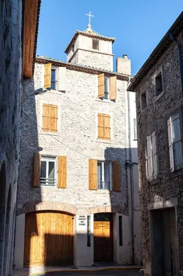 an old stone building with wooden doors and a tower at Studio du Maire Maison de L'Église du Couvent in Narbonne