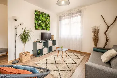 a living room with a couch and a tv at Cosy Green Clim Wifi Centre ville 2 pers in Lézignan-Corbières