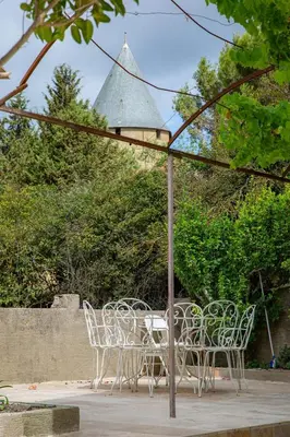 a group of chairs and a table under an umbrella at Les Pimprenelles in Carcassonne