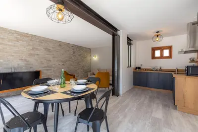 a dining room and kitchen with a table and chairs at Les Pimprenelles in Carcassonne