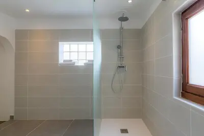 a shower with a glass door in a bathroom at Les Pimprenelles in Carcassonne