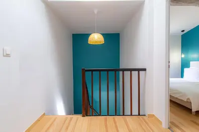 a bedroom with a blue accent wall and a bed at Les Pimprenelles in Carcassonne