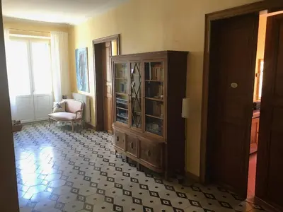 a living room with a cabinet and a chair at Maison La vie est belle in Luc-sur-Orbieu