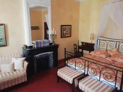 a bedroom with a bed and a chair and a fireplace at Maison La vie est belle in Luc-sur-Orbieu
