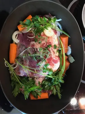a pan filled with meat and vegetables on a stove at Maison La vie est belle in Luc-sur-Orbieu