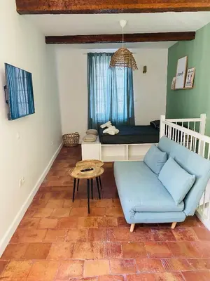 a living room with a blue couch and a bed at La Dolce Vita in Carcassonne