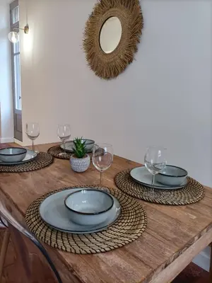 a wooden table with plates and wine glasses on it at La Dolce Vita in Carcassonne