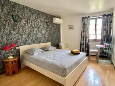 a bedroom with a bed and a wall with floral wallpaper at Appartement Cité de Carcassonne in Carcassonne