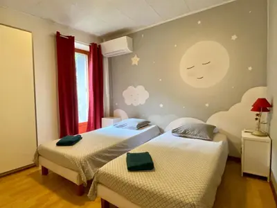 two beds in a room with a moon mural on the wall at Appartement Cité de Carcassonne in Carcassonne