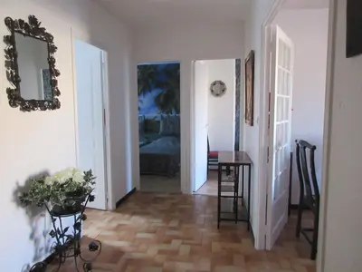 a hallway with a room with a table and a couch at Appartement Cité de Carcassonne in Carcassonne