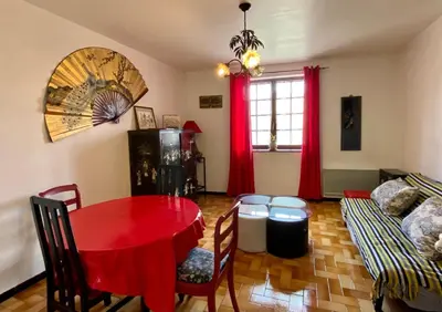 a living room with a red table and a couch at Appartement Cité de Carcassonne in Carcassonne