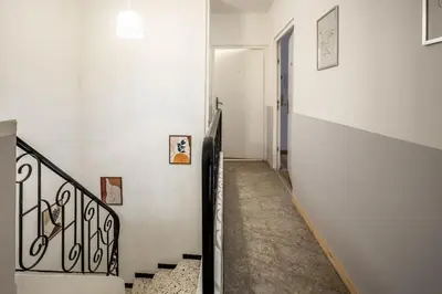 a stairway with a white wall and a white stair case at Studio Marceau Clim Wifi Centre ville 2 pers in Lézignan-Corbières