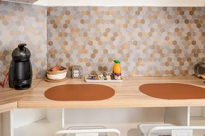 a kitchen counter with two circles on the wall at Studio Marceau Clim Wifi Centre ville 2 pers in Lézignan-Corbières