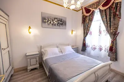 a bedroom with a bed and a window with a chandelier at Appartement Maison de L'Église du Couvent in Narbonne