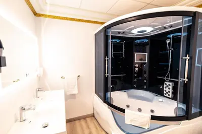 a bathroom with a tub and a large mirror at Appartement Maison de L'Église du Couvent in Narbonne