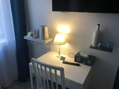 a table with a lamp on it with a chair at La Vie en Roses in Rennes-les-Bains