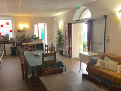 a living room with a table and a couch at La Vie en Roses in Rennes-les-Bains