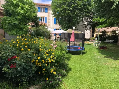 a garden with a swimming pool and some flowers at La Vie en Roses in Rennes-les-Bains