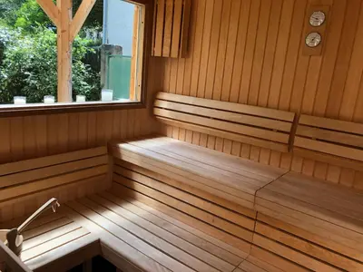 a sauna with two benches and a window at La Vie en Roses in Rennes-les-Bains