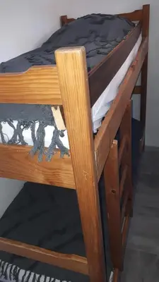 a wooden bunk bed with a black comforter on it at Studio cabine avec jardinet à 30 m de la plage, au calme. in Gruissan
